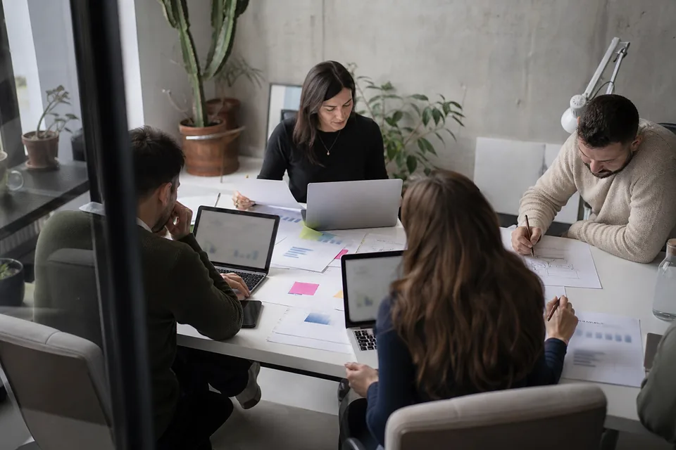 Agency team comparing store reports on laptops around a table